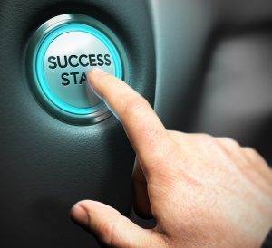 One big button with the text success start and a finger pressing the center, illustration of business performance and commercial motivation. 
This conceptual picture is a combination between a 3D render and a digital photography with depth of field effect.